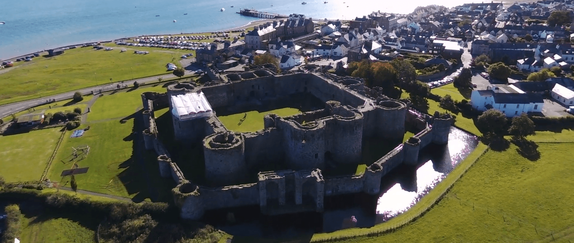 Beaumaris Castle towers rising above the moat